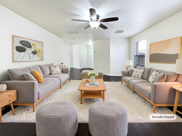 living room featuring ceiling fan and dark wood-type flooring