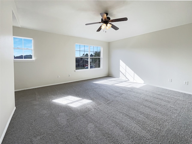 carpeted spare room featuring plenty of natural light and ceiling fan