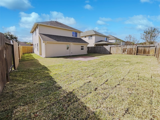 rear view of house featuring a lawn and a patio