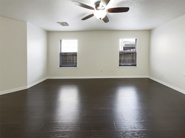 empty room with ceiling fan, dark hardwood / wood-style flooring, and a textured ceiling