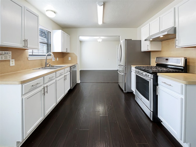 kitchen featuring appliances with stainless steel finishes, white cabinetry, dark wood-type flooring, and sink