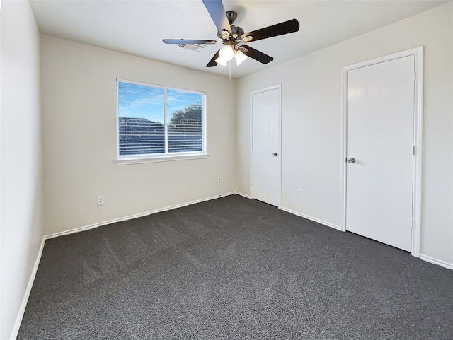 unfurnished bedroom with dark colored carpet and ceiling fan