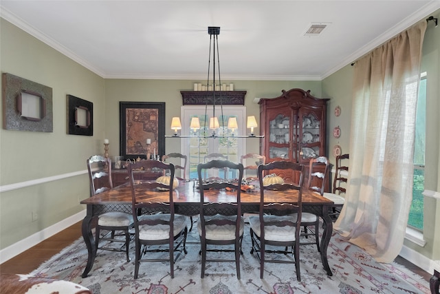 dining space with a chandelier, wood-type flooring, and crown molding