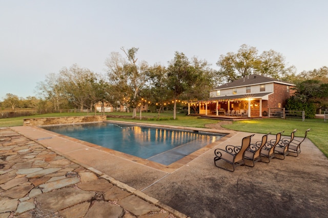 view of pool with a lawn and a patio area