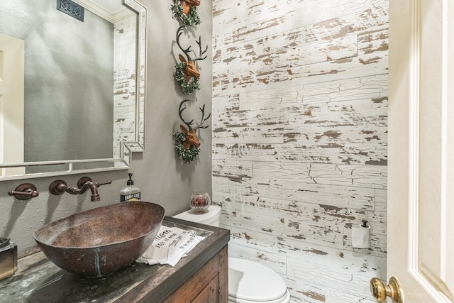 bathroom with crown molding, vanity, and toilet