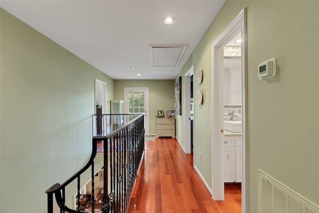 hall with sink and light wood-type flooring