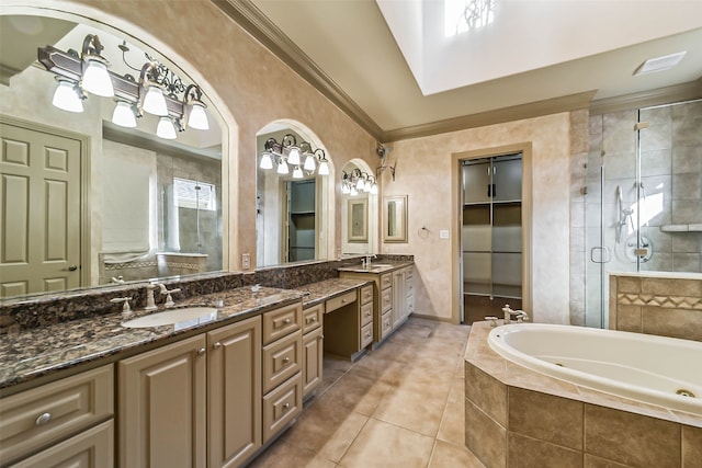 bathroom with a skylight, tile patterned floors, crown molding, shower with separate bathtub, and vanity