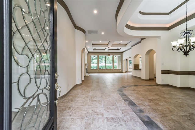 foyer entrance featuring ornamental molding and an inviting chandelier