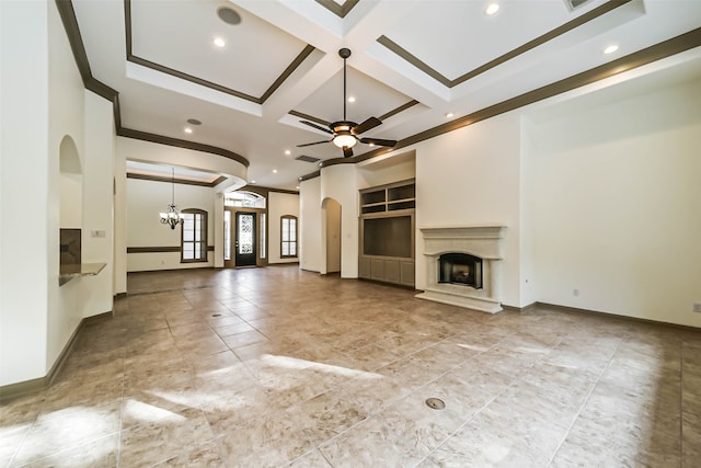 unfurnished living room featuring ornamental molding, ceiling fan with notable chandelier, coffered ceiling, and beam ceiling