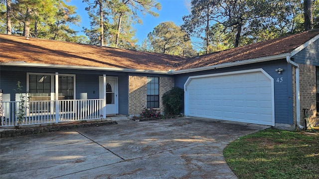 ranch-style house featuring an attached garage, a porch, concrete driveway, and brick siding