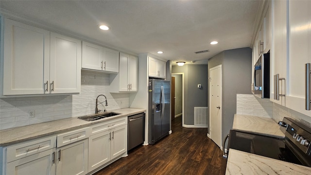 kitchen with dark wood-type flooring, sink, light stone countertops, white cabinetry, and stainless steel appliances