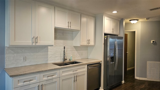 kitchen featuring white cabinets, sink, light stone countertops, appliances with stainless steel finishes, and dark hardwood / wood-style flooring