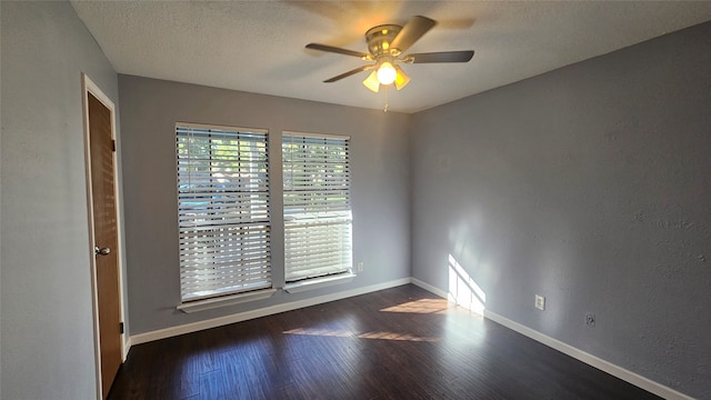 spare room featuring dark hardwood / wood-style floors, ceiling fan, and a textured ceiling