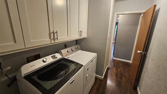 washroom with cabinets, dark hardwood / wood-style flooring, and washing machine and dryer