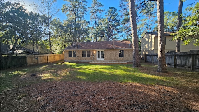 rear view of house featuring french doors and a lawn