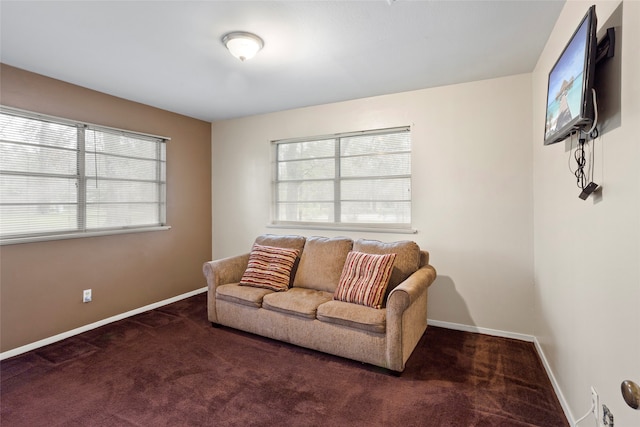 living room featuring a healthy amount of sunlight and dark carpet