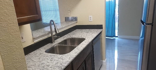 kitchen featuring light stone counters, sink, and stainless steel appliances