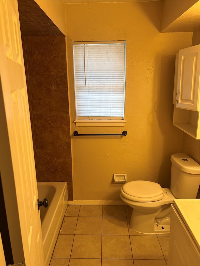 bathroom featuring tile patterned flooring, vanity, toilet, and a bathing tub