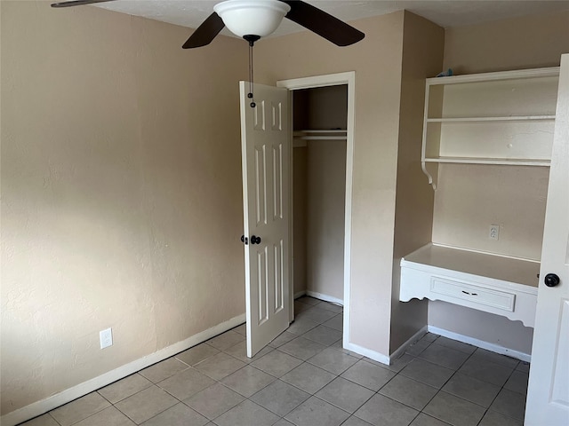 unfurnished bedroom featuring ceiling fan, light tile patterned floors, and a closet