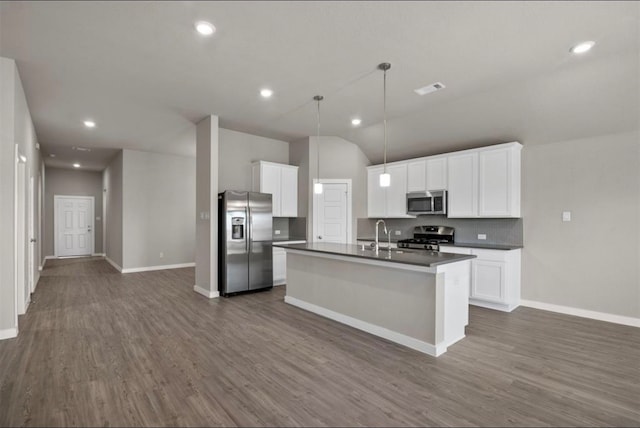 kitchen with dark wood-type flooring, hanging light fixtures, an island with sink, white cabinets, and appliances with stainless steel finishes