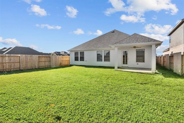 rear view of property featuring ceiling fan, a yard, and a patio