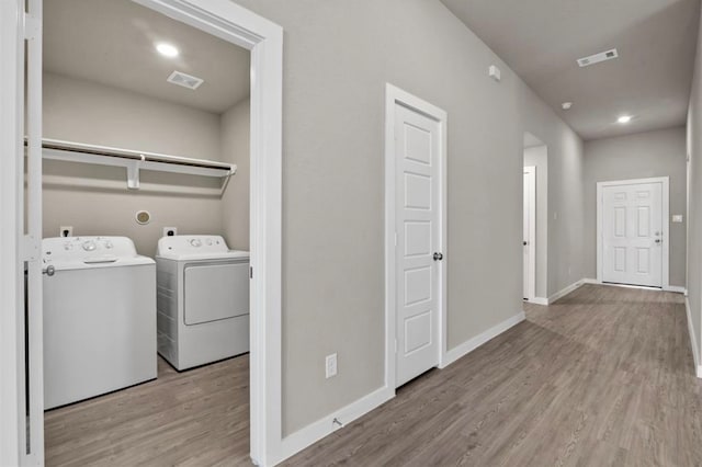 laundry room with light wood-type flooring and separate washer and dryer