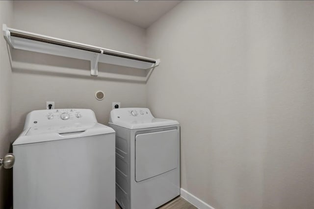 laundry area featuring washer and clothes dryer and wood-type flooring