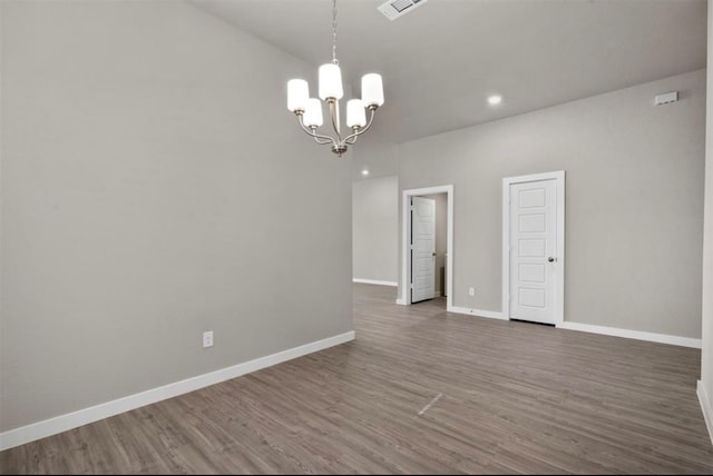 unfurnished room with dark wood-type flooring and a chandelier