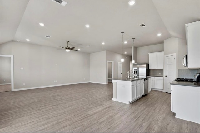 kitchen featuring white cabinetry, ceiling fan, a center island with sink, appliances with stainless steel finishes, and light wood-type flooring