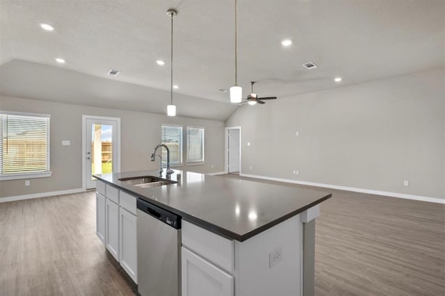 kitchen with sink, a healthy amount of sunlight, stainless steel dishwasher, vaulted ceiling, and white cabinets