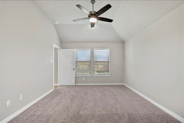 empty room featuring ceiling fan, lofted ceiling, and light carpet