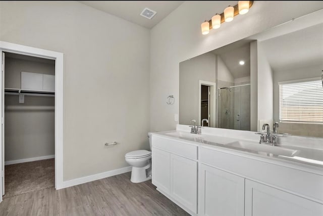 bathroom featuring a shower with shower door, vanity, hardwood / wood-style floors, toilet, and lofted ceiling