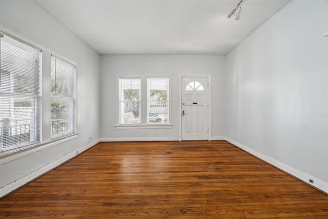 entryway with dark hardwood / wood-style flooring and track lighting