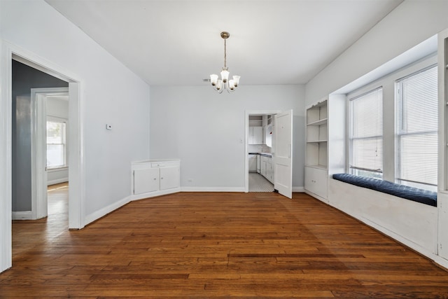 unfurnished dining area with dark wood-type flooring and a chandelier