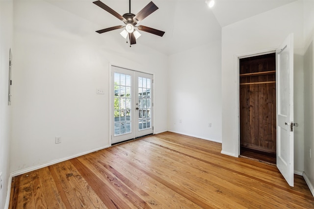 unfurnished bedroom with hardwood / wood-style floors, lofted ceiling, french doors, ceiling fan, and a closet