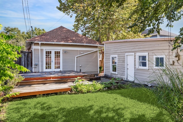 rear view of house with a lawn, french doors, and a deck