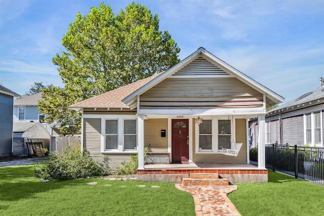 bungalow with covered porch and a front yard