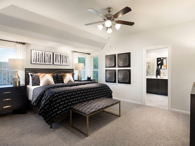 bedroom with ceiling fan, light colored carpet, ensuite bathroom, and vaulted ceiling