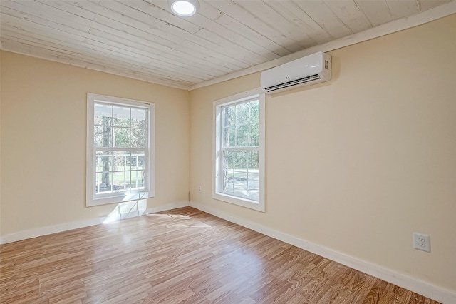 unfurnished room featuring a wealth of natural light, a wall unit AC, and light hardwood / wood-style flooring