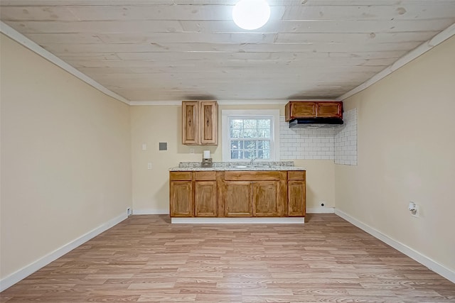 kitchen featuring sink, light wood-type flooring, and ornamental molding