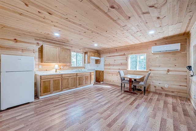 kitchen with a wealth of natural light, white fridge, and light hardwood / wood-style floors