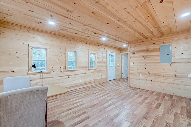 bonus room featuring light wood-type flooring, electric panel, wooden ceiling, and wood walls