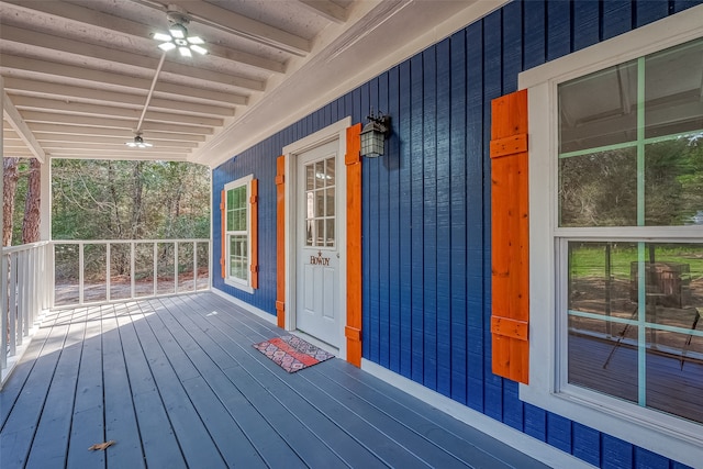 wooden terrace with ceiling fan and covered porch