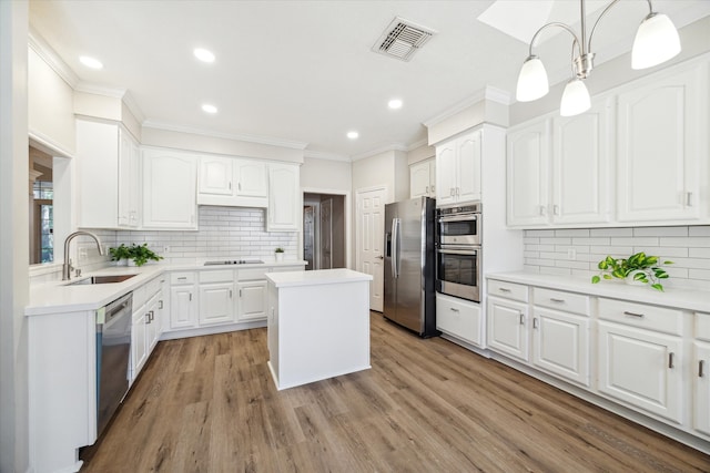 kitchen with white cabinetry, sink, a center island, stainless steel appliances, and light hardwood / wood-style floors