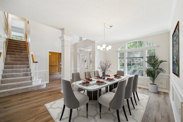 dining area featuring a healthy amount of sunlight, light hardwood / wood-style floors, ornamental molding, and a chandelier