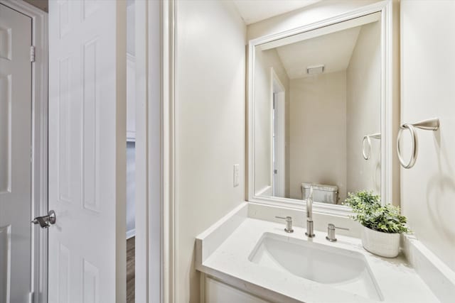 bathroom with hardwood / wood-style flooring, vanity, and toilet