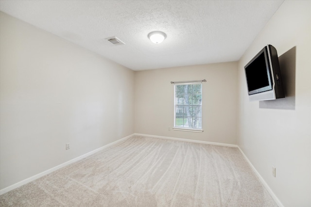 carpeted spare room with a textured ceiling