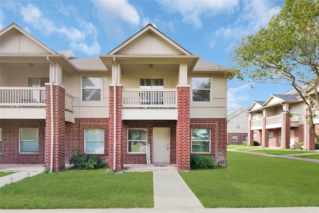 townhome / multi-family property with a front yard