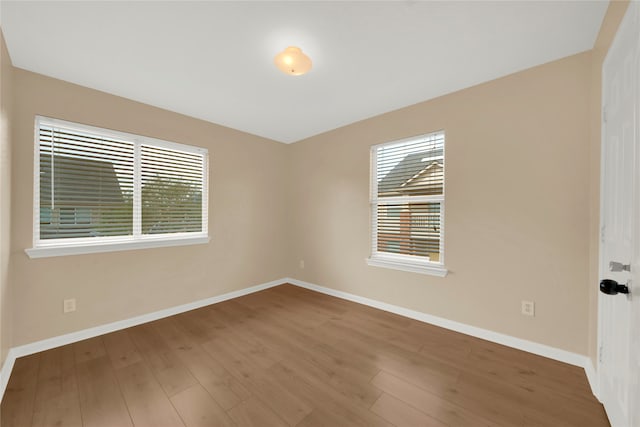 spare room with hardwood / wood-style floors and a healthy amount of sunlight