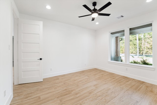 spare room with ceiling fan and light wood-type flooring